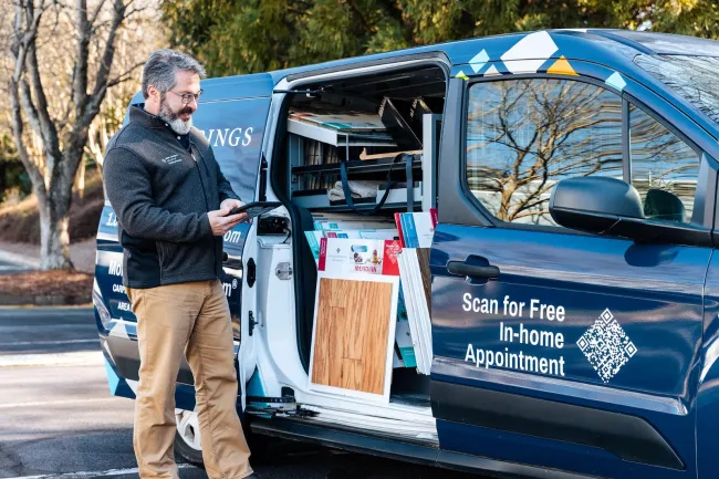An FCI employee standing by a company van