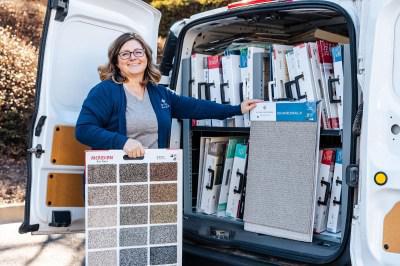 Woman with carpet samples at the back of an FCI mobile showroom