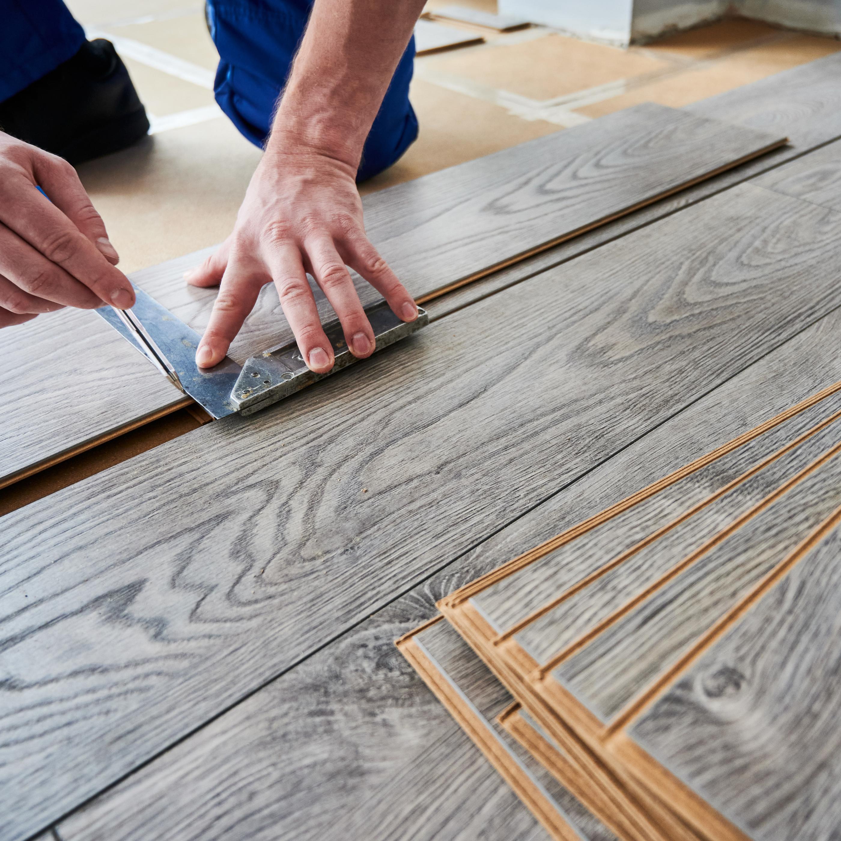 Laminate flooring being installed over existing tile for a refreshed look.