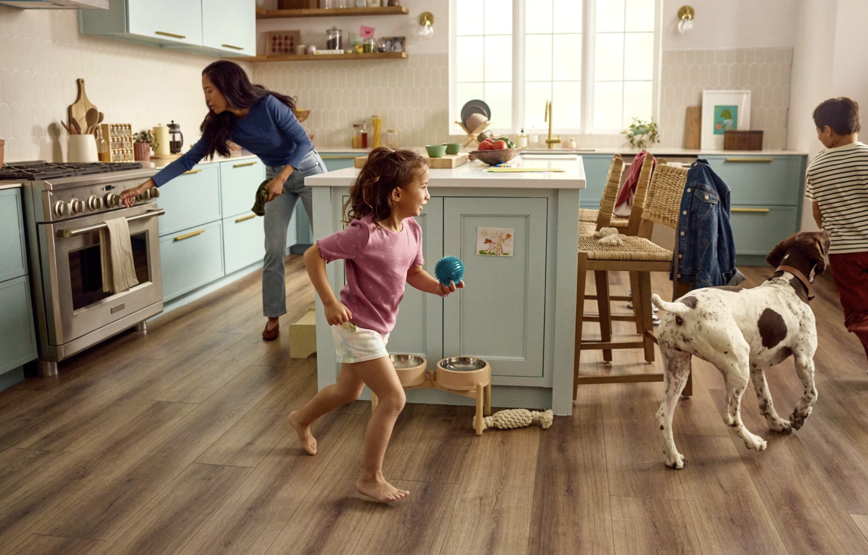 kids running around kitchen island with dog